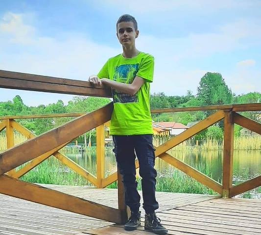 Chłopiec stojący na moście drewnianym
