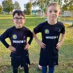 Dwaj chłopcy ubrani w czarne stroje sportowe