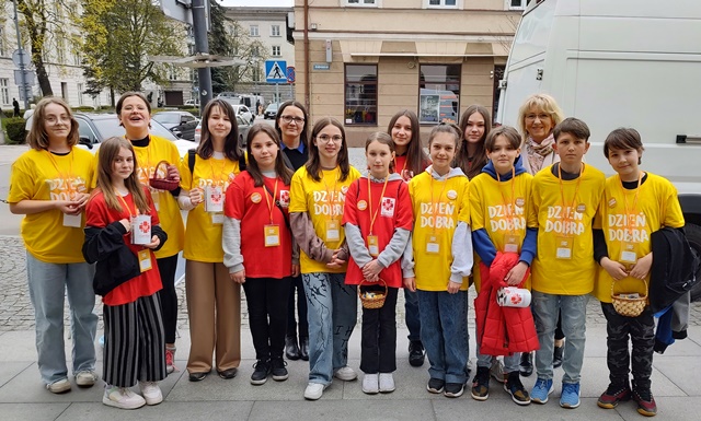 Uczniowie w żółtych i czerwonych koszulkach z napisem Dzień dobra