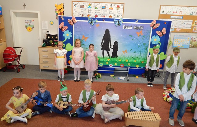 Dzieci ubrane w odświętne stroje grające na instrumentach
