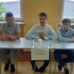 Trzej chłopcy siedzący przy stoliku