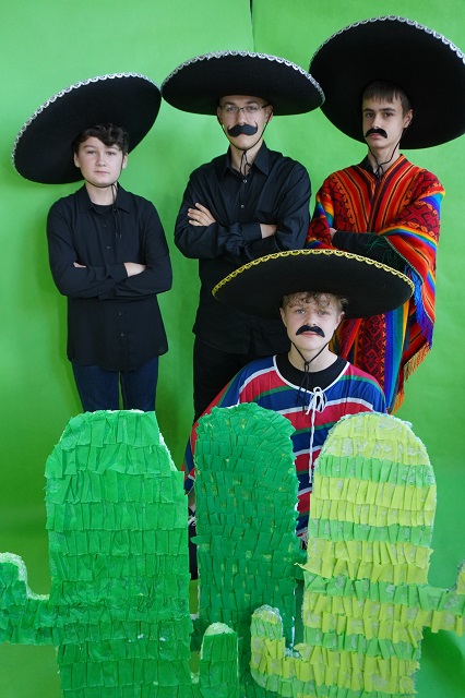 Uczniowie w kapeluszach na zielonym tle