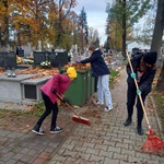 Uczniowie grabiący liście na cmentarzu
