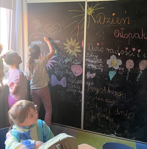 Dzieci w świetlicy piszą na tablicy
