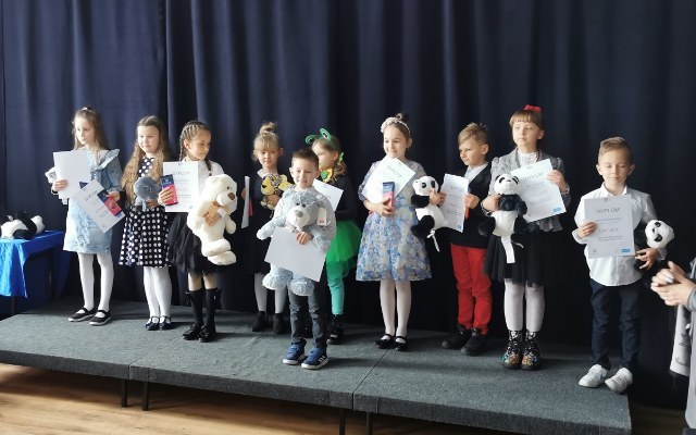 Dzieci z nagrodami stojące na scenie
