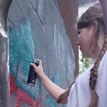 Dziewczynka malująca sprayem mur