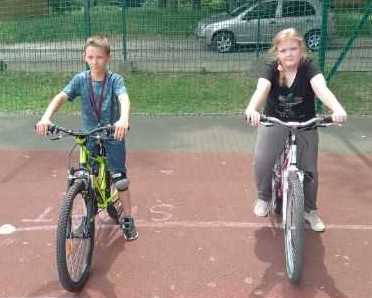Uczniowie na rowerze w miasteczku mobilnym